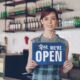 Small business owner welcoming new customers while learning how to get more customers for my small business