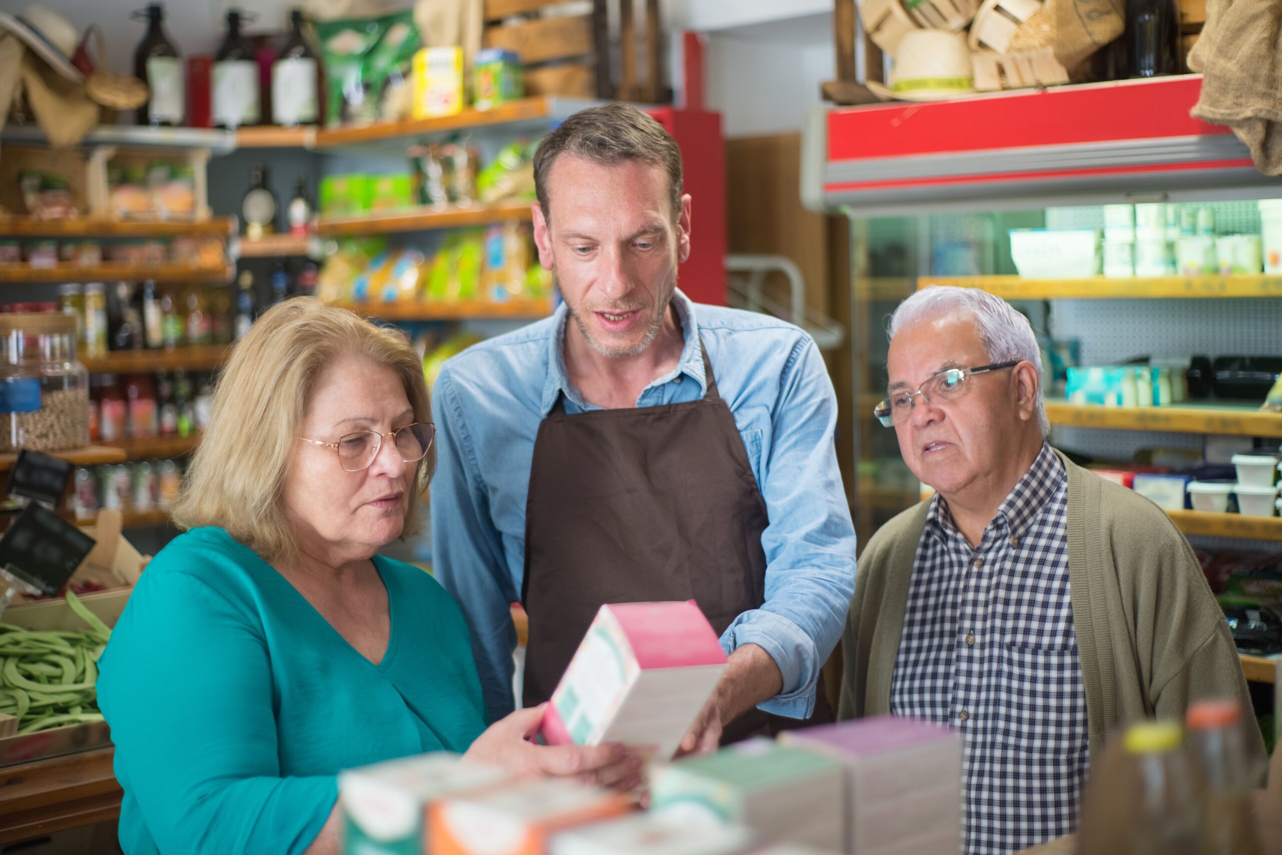 Shopkeeper helping customers in a small shop