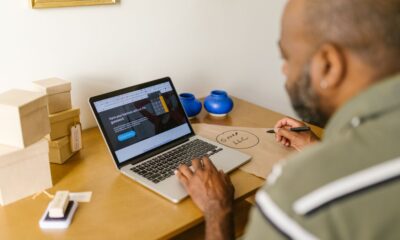 A small business owner writing an overdue invoice reminder email on a laptop.