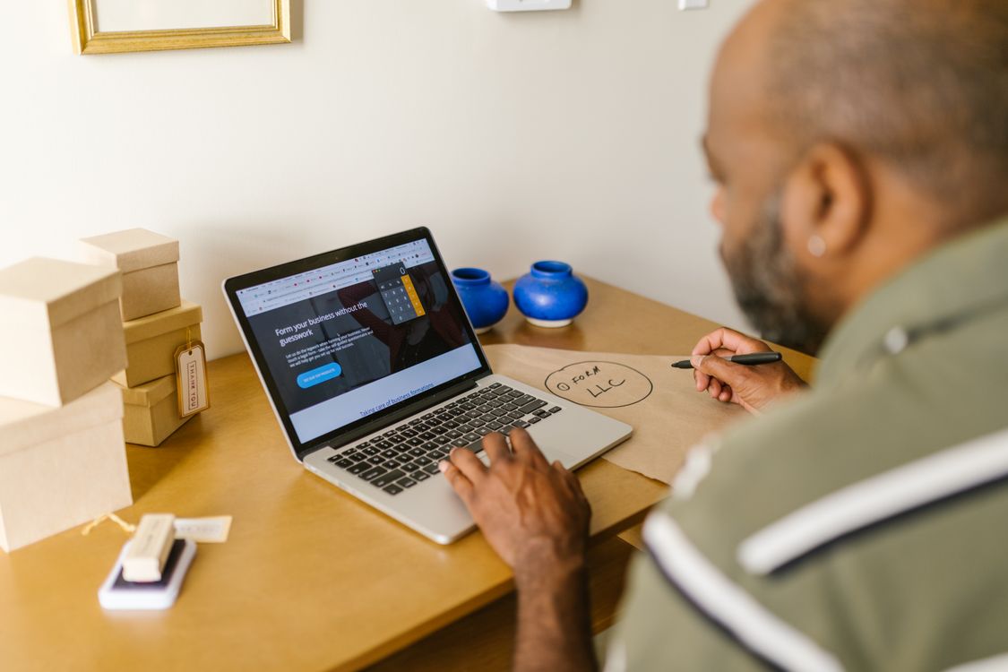 A small business owner writing an overdue invoice reminder email on a laptop.
