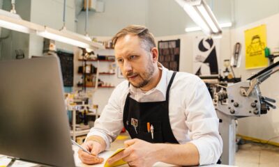 Local SEO for small business: a shop owner checking nearby search results on a laptop in a small shop