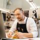 Local SEO for small business: a shop owner checking nearby search results on a laptop in a small shop