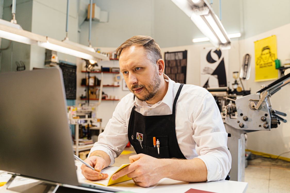Local SEO for small business: a shop owner checking nearby search results on a laptop in a small shop