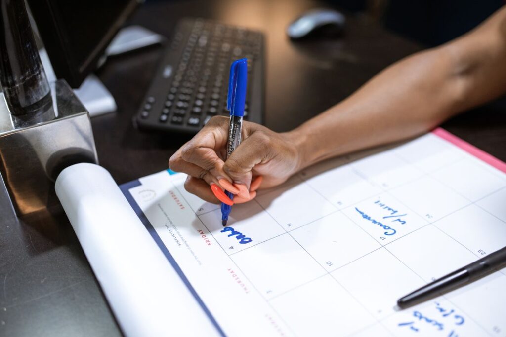 Employee Retention Strategies for Small Businesses: Simple Ways to Keep Good People 42 A small business team member writing notes during a check-in, supporting employee retention