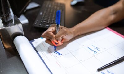 A person writing notes on a calendar while planning how to create a content calendar for small business