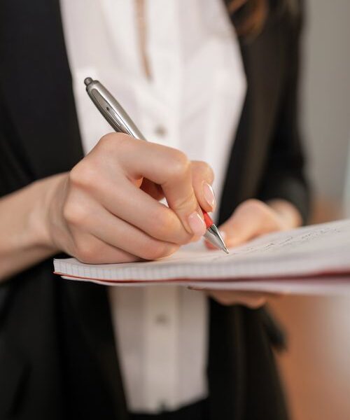 Small business owner planning notes in a notebook, showing how to set SMART goals for small business